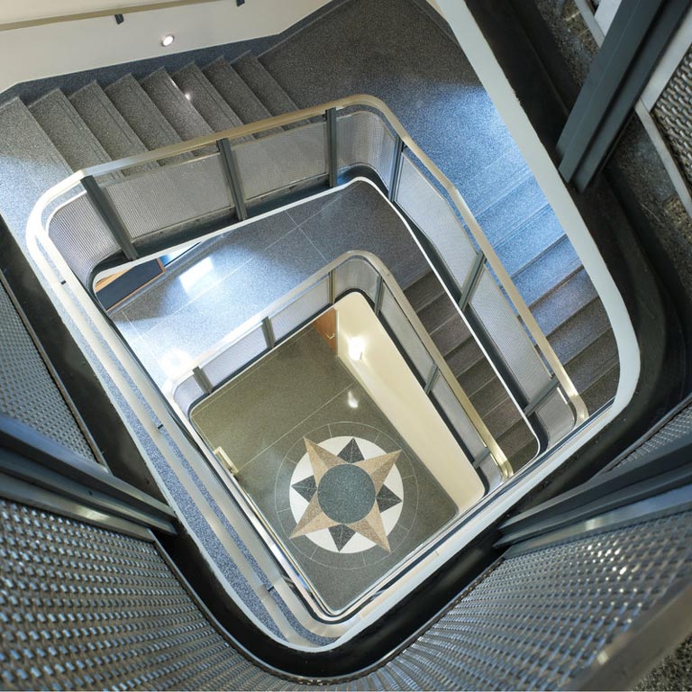A geometric pattern on the floor of Simon Hall as seen through the upper staircase.